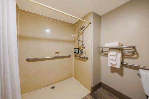 a bathroom with a shower and a toilet with towels at Best Western Inn & Suites Lemoore in Lemoore