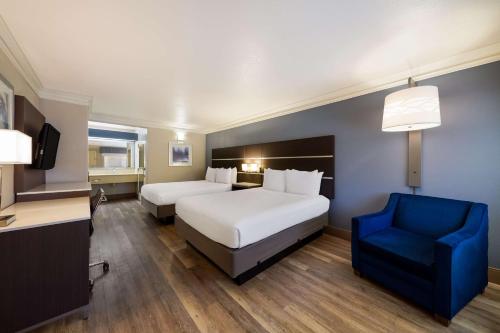 a hotel room with two beds and a blue chair at Best Western Inn & Suites Lemoore in Lemoore