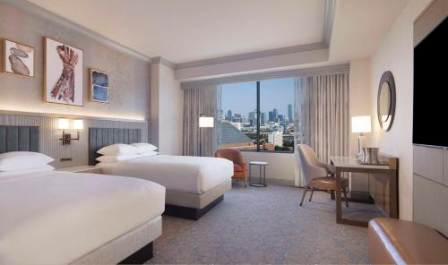 a hotel room with two beds and a desk at Hilton Anatole in Dallas