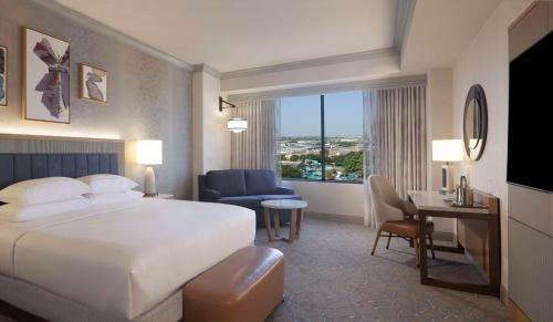 a hotel room with a large bed and a desk at Hilton Anatole in Dallas