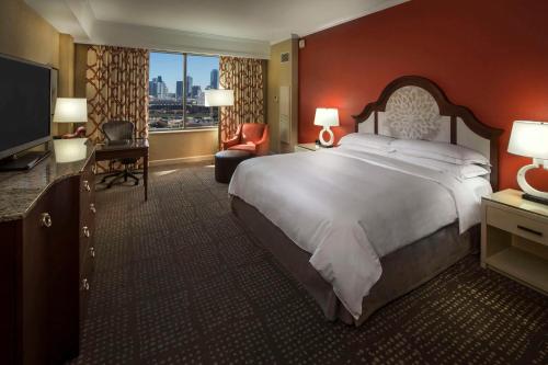 a hotel room with a large bed and a television at Hilton Anatole in Dallas