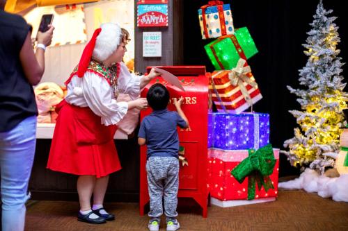 a woman and a child standing next to christmas presents at Hilton Anatole in Dallas