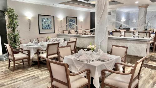 un comedor con mesas y sillas y un restaurante en Hotel Quinta Real, en La Ceiba