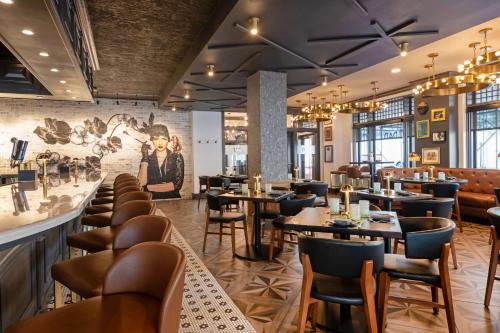 a restaurant with tables and chairs and a mural at Hotel Flor Tampa Downtown, Tapestry Collection By Hilton in Tampa