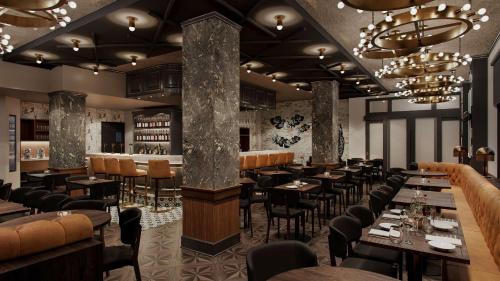 a restaurant with tables and chairs and a bar at Hotel Flor Tampa Downtown, Tapestry Collection By Hilton in Tampa