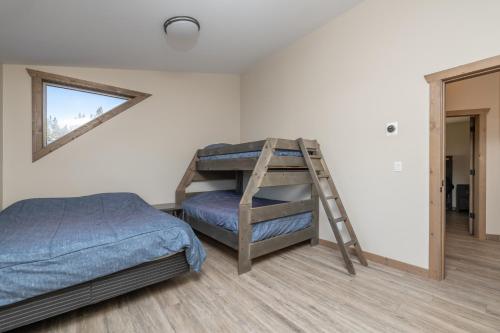 a bedroom with a bunk bed and a ladder at Sunny Peaks in Valemount