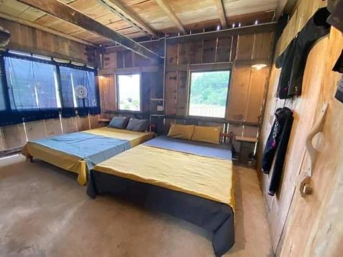 a room with two beds and two windows at Lũng Mười Homestay in Nà Giảo