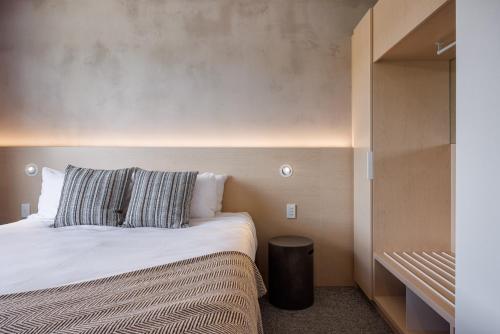 a small bedroom with a bed and a closet at Village Apartments at NZCIS in Upper Hutt