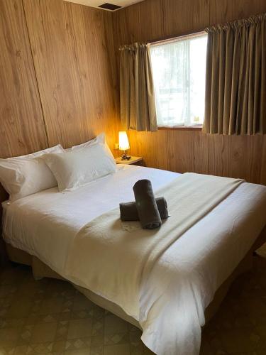 a bedroom with a large white bed with a window at Mansfield Lakeside Caravan Park in Mansfield