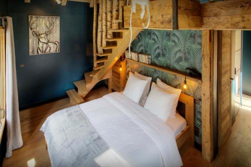 a bedroom with a bed and a staircase at Chalet 1703 - OVO Network in Le Petit-Bornand-lès-Glières