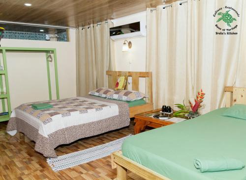 a bedroom with two beds and a wooden floor at Casa el Tortugo in Drake