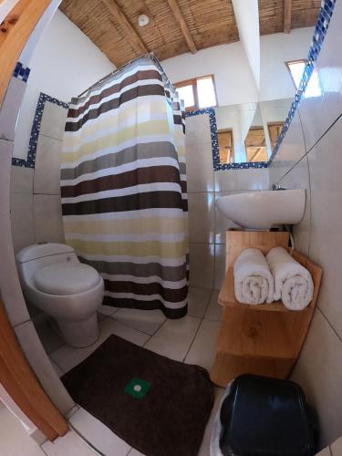 a small bathroom with a toilet and a sink at Lobitos Eco Lodge in Lobitos