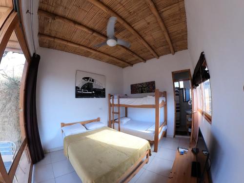 Schlafzimmer mit einem Bett und einem Deckenventilator in der Unterkunft Lobitos Eco Lodge in Lobitos