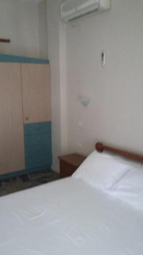 a bedroom with a white bed in a room at Holiday Tolofona Beach in Eratini