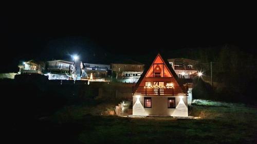 a small house with a red roof at night at KoCHALET Apartment in Crni Vrh