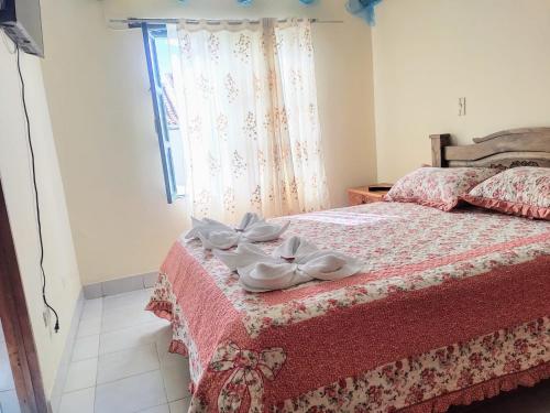 Un dormitorio con una cama con zapatos blancos. en ABI HAPPY, en Villa de Leyva