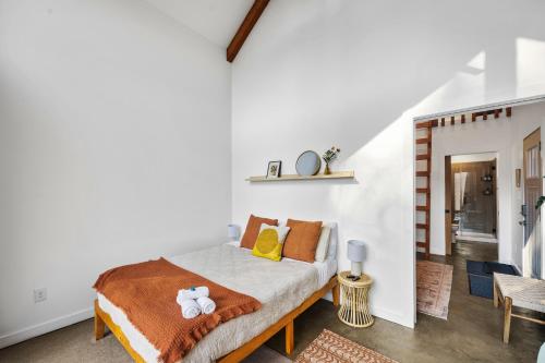 a bedroom with a bed with yellow and orange pillows at Tiny Cabin in RRG - The Taoist in Rogers
