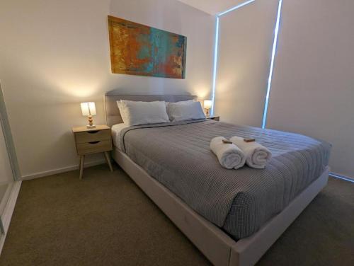 a bedroom with a bed with two towels on it at Newcastle Interchange Apartments in Wickham
