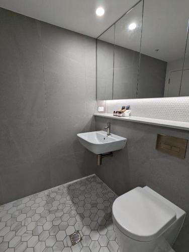 W łazience znajduje się umywalka, toaleta i lustro. w obiekcie Newcastle Interchange Apartments w mieście Wickham