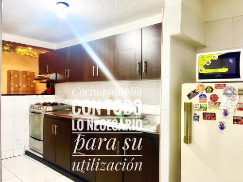 uma cozinha com frigorífico e escrita em A 5 minutos del Aeropuerto el Dorado em Bogotá
