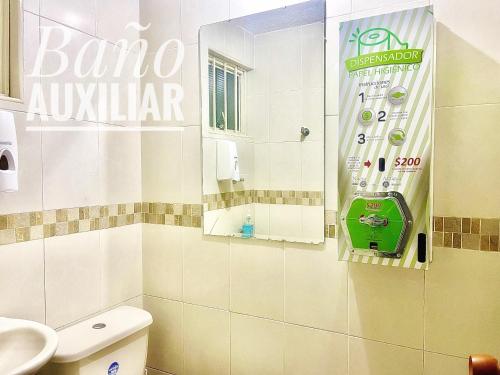uma casa de banho com um WC branco e um espelho. em A 5 minutos del Aeropuerto el Dorado em Bogotá