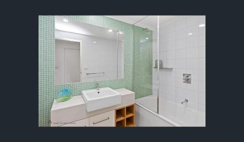 a bathroom with a sink and a mirror and a tub at Apollo Blue Ocean View Unit 1-A Free WIFI in Apollo Bay