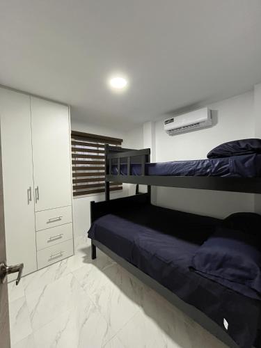 1 Schlafzimmer mit 2 Etagenbetten und einem Schrank in der Unterkunft Casa Familiar a Pasos del Mar Playa y Felicidad in Manta