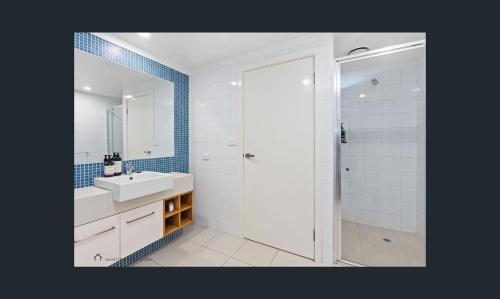 a white bathroom with a sink and a shower at Apollo Blue Oceanview Unit 1- B Free WIFI in Apollo Bay