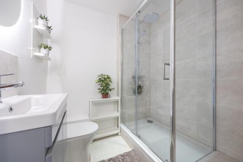 a bathroom with a shower and a toilet and a sink at Victoria Brand new, cosy 1 bed apartment in London