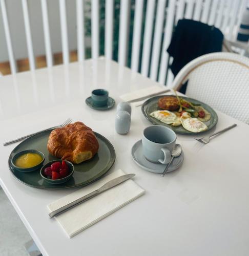 a table with plates of food and a cup of coffee at Nassau Suite South Beach, an All Suite Hotel in Miami Beach