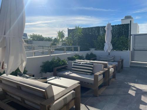 a group of chairs and umbrellas on a balcony at Nassau Suite South Beach, an All Suite Hotel in Miami Beach