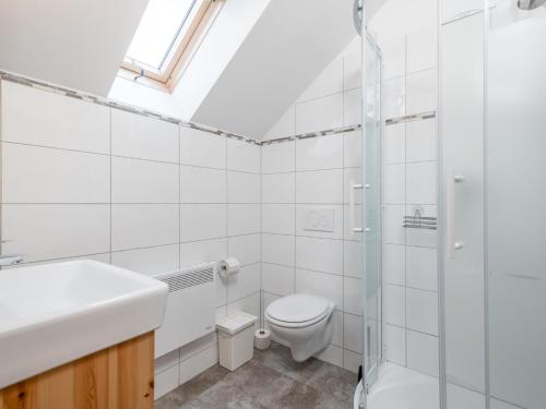 een witte badkamer met een toilet en een wastafel bij Wolfgangchalet C in Mauterndorf