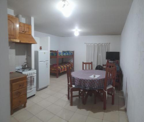 聖拉斐爾的住宿－Deptos Av Moreno，厨房配有桌椅和冰箱。