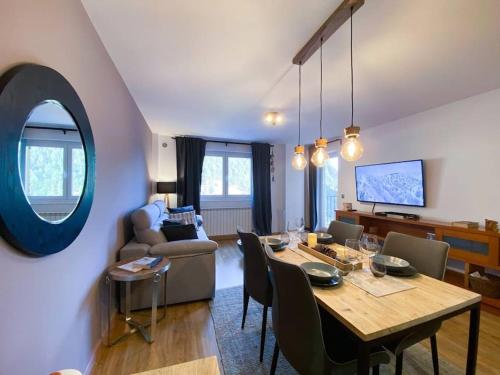 a living room with a table and a dining room at Iconic Vistas Arinsal 431 - Pie de Pistas y 1plaza Parking in Arinsal