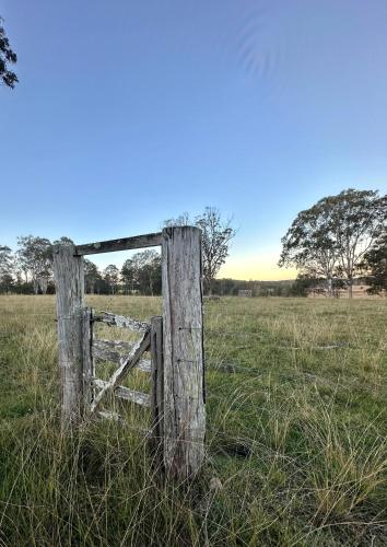 an old wooden fence in a field of grass at Farmstay - LJHooker Yamba in Maclean
