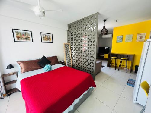 a bedroom with a bed with a red blanket at Loft london, estilo e praticidade no coração de Icarai in Niterói