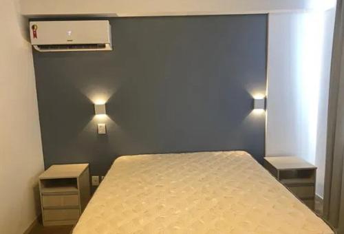 um quarto com uma cama com duas mesas de cabeceira e duas luzes em Casa de praia curtição em Contagem