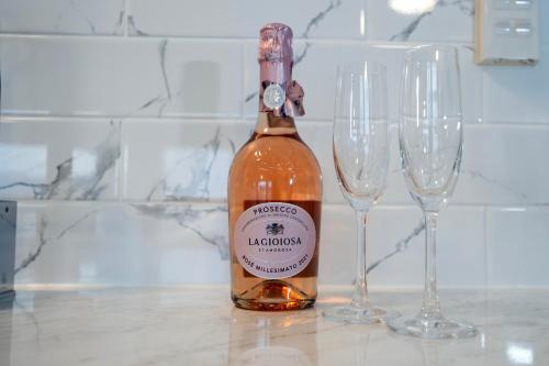 a bottle of wine next to two wine glasses at Waterfront Apartments Whitianga in Whitianga