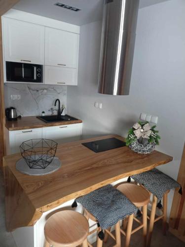 a kitchen with a wooden counter with stools and a sink at Domek na Górce in Zakopane