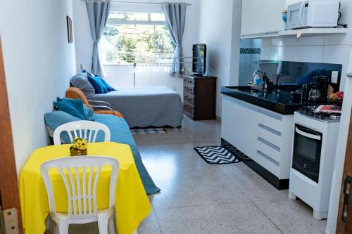 eine kleine Küche mit einem gelben Tisch in einem Zimmer in der Unterkunft Otimo studio c WiFi no centro de Pedro Leopoldo MG in Pedro Leopoldo