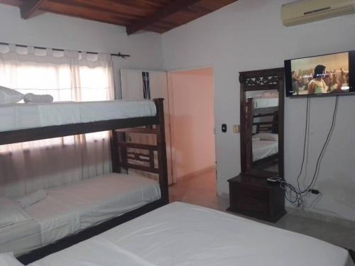 1 dormitorio con 2 literas y espejo en VIVIENDA TURISTICA GAIRA, en Rodadero