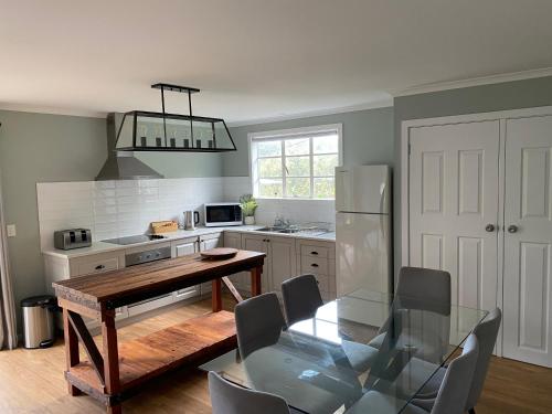 a kitchen with a table and chairs and a refrigerator at 3 Bedroom Holiday house in Halls Gap