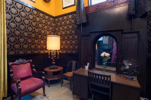 a living room with a chair and a mirror at The Rosemary in Los Angeles