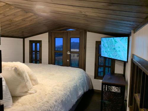 una camera con letto e TV a schermo piatto di EntreNubes, Chalet de montaña a La Calera