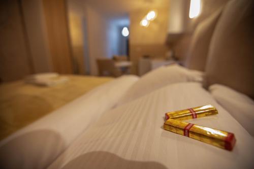 a gold bottle on a bed in a hotel room at Lotos Apartments in Kruševac