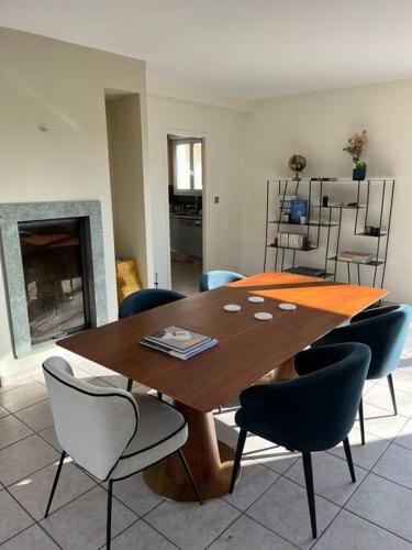 une salle à manger avec une table et des chaises en bois dans l'établissement Villa piscine proche de Genève et du Jura, à Saint-Genis-Pouilly
