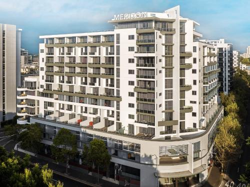 a white building with a sign on top of it at Meriton Suites Waterloo in Sydney