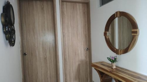 a bathroom with a wooden door and a mirror at Cabaña Apartamento En Coveñas - Fontaine Bleu in Coveñas