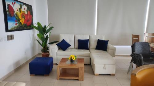 a living room with a white couch and blue pillows at Cabaña Apartamento En Coveñas - Fontaine Bleu in Coveñas