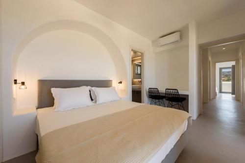 a bedroom with a large bed and a table and chairs at Aegean Gem Villa with private pool in Paros in Mármara